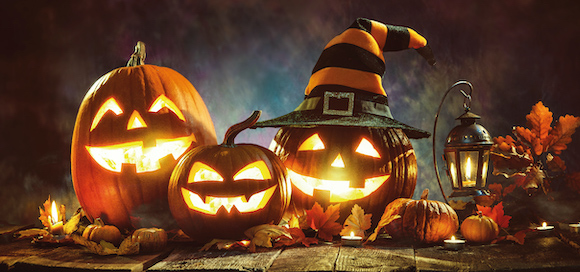 Illuminated Jack o' lantern pumpkins in a row
